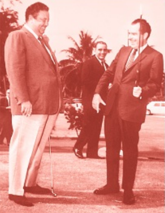 Red-tinted photograph of Richard Nixon and Doug Milford with golf clubs