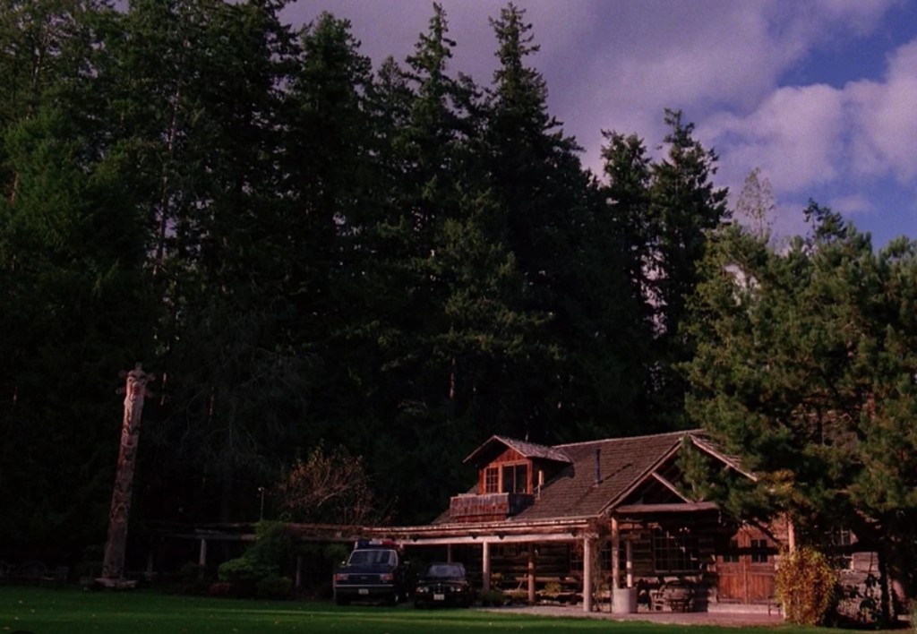 Blue Pine Lodge on Black Lake — log house, totem, forest at dusk