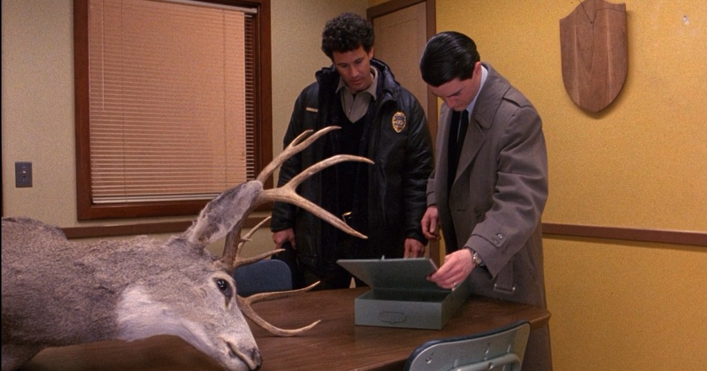 Cooper and Truman open Laura’s safe-deposit box; deer head on the table