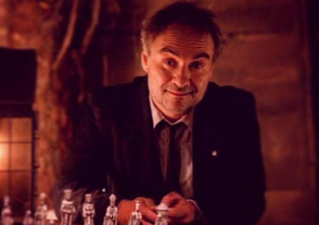 Windom Earle at the chessboard — lantern light, calculating smile