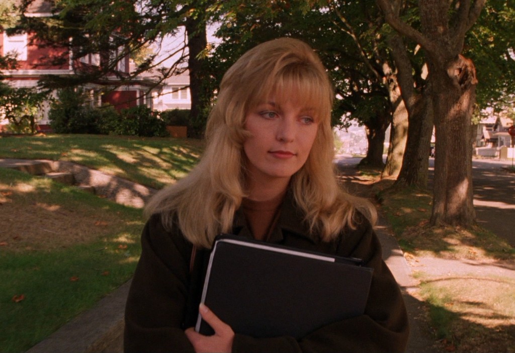 Laura Palmer walking with a Meals on Wheels binder on a Twin Peaks sidewalk