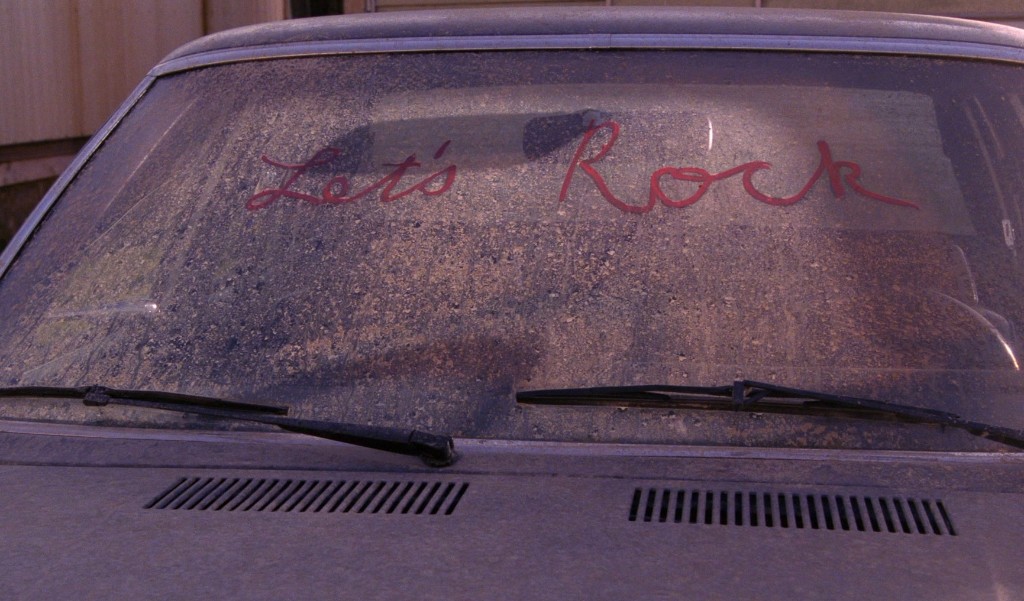 Desmond's abandoned car at Fat Trout - LET'S ROCK written in lipstick on the dusty windshield