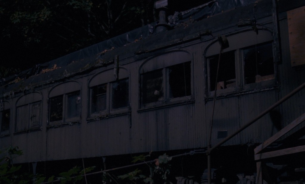 Abandoned wooden train car in the woods at night - the murder site
