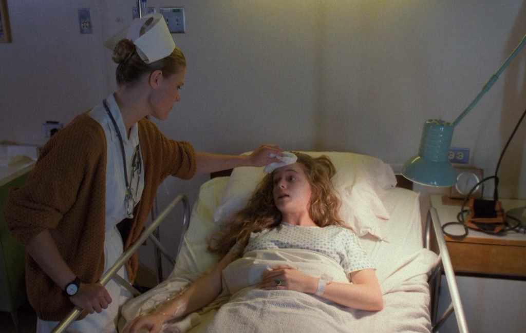 Annie Blackburn in a hospital bed - a nurse tends to her forehead