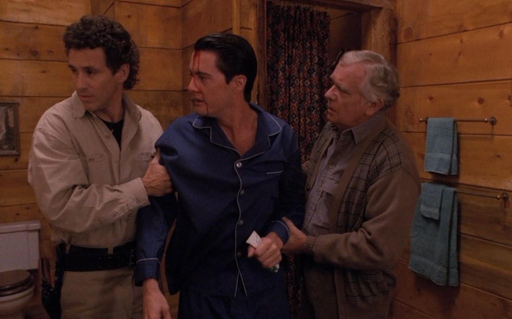 Cooper's doppelgänger with blood on his face, steadied by Sheriff Truman and Doc Hayward